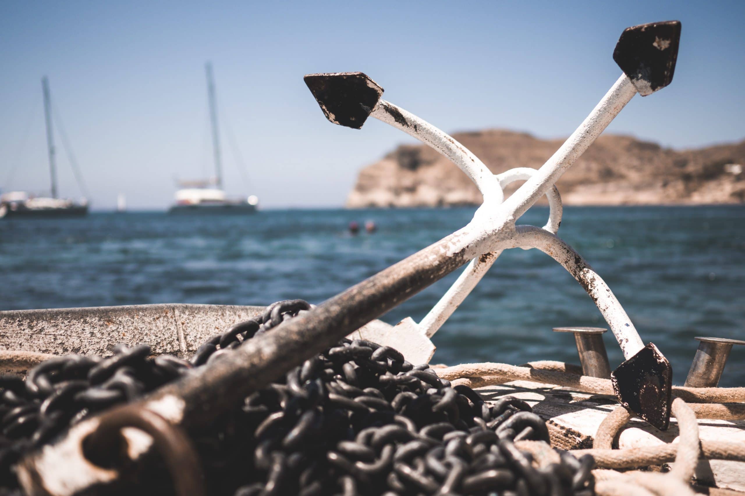 Real anchor and chains on a deck by the sea