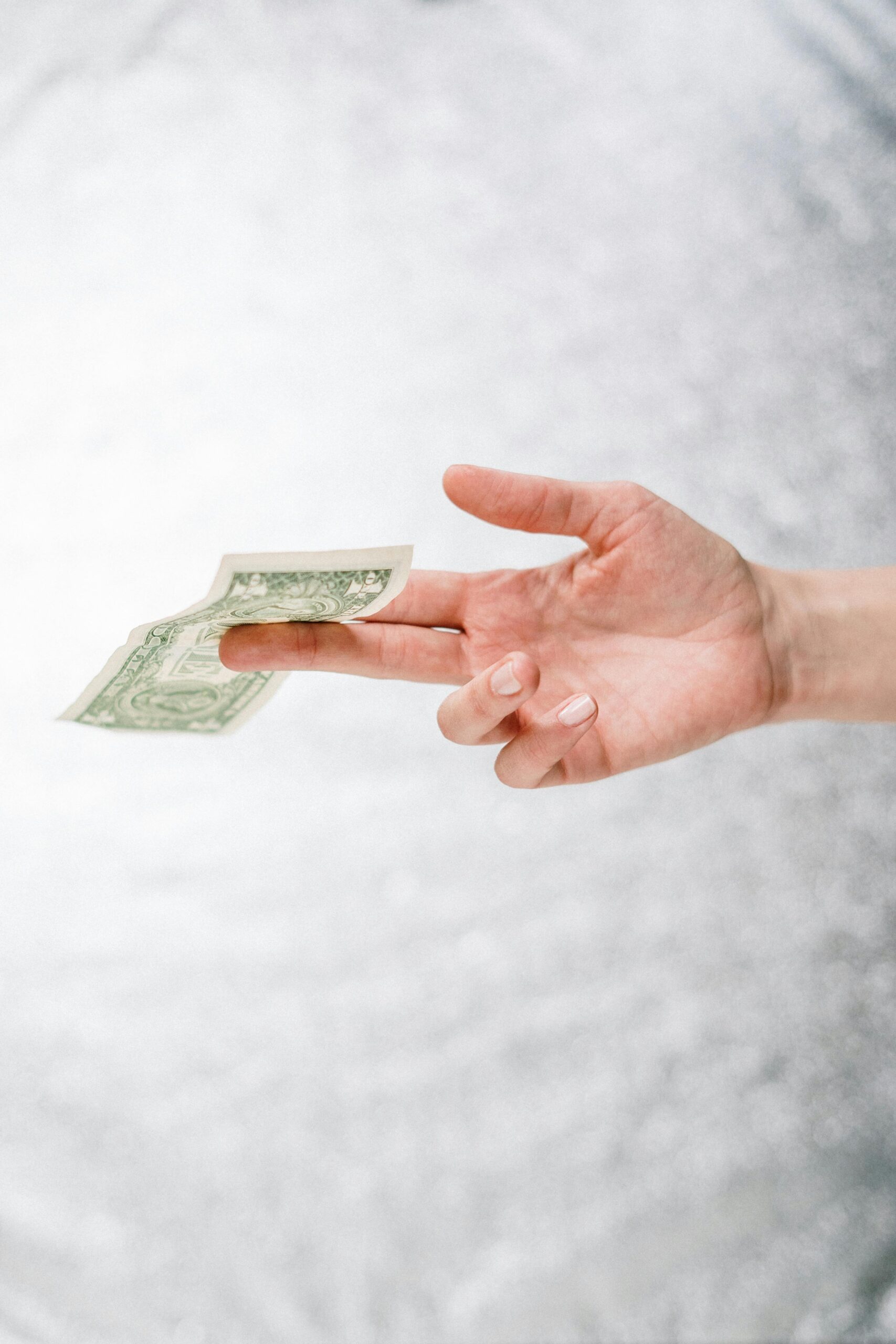 Hand holding a banknote - as if plucked from mid air