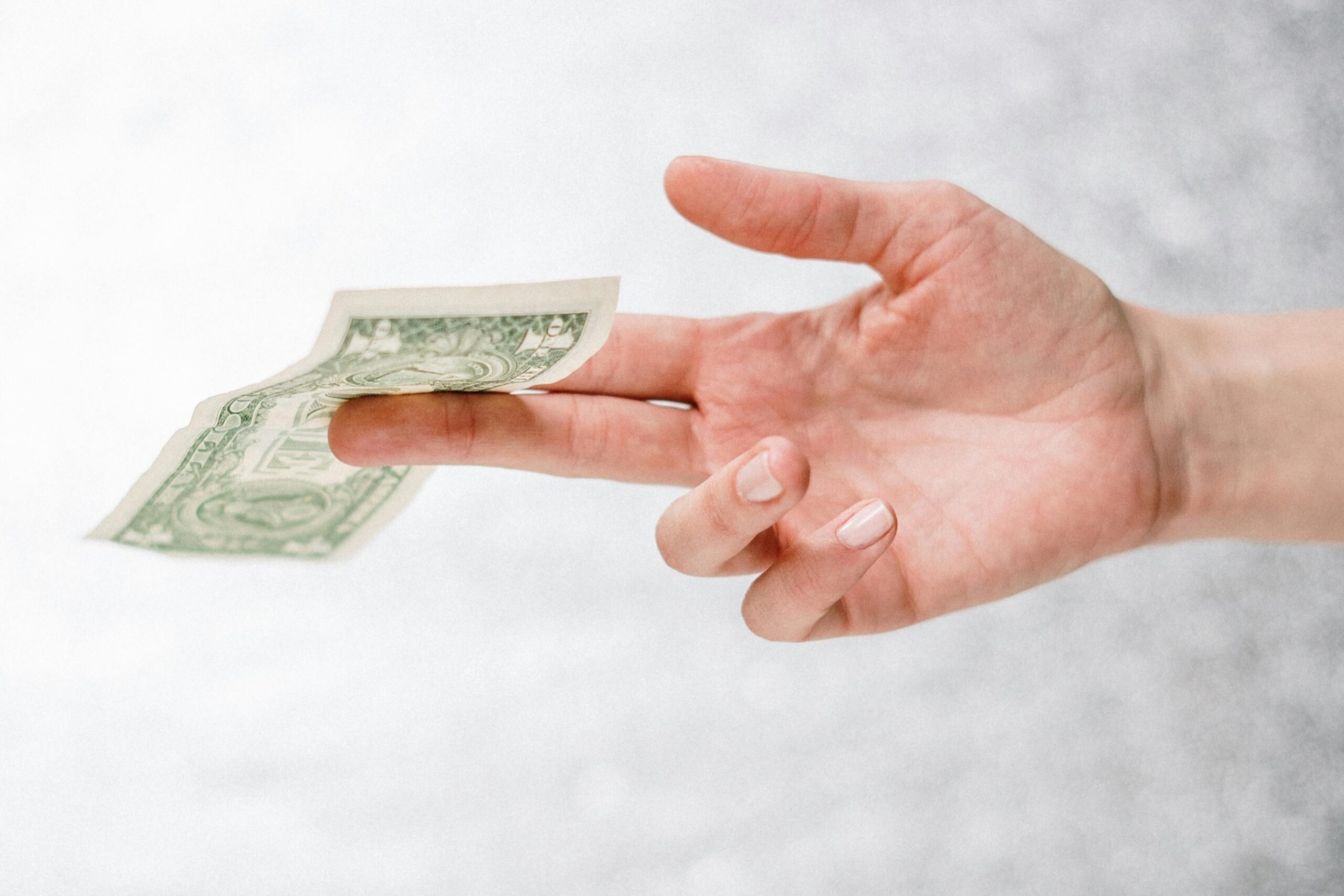 Hand holding a banknote - as if plucked from mid air
