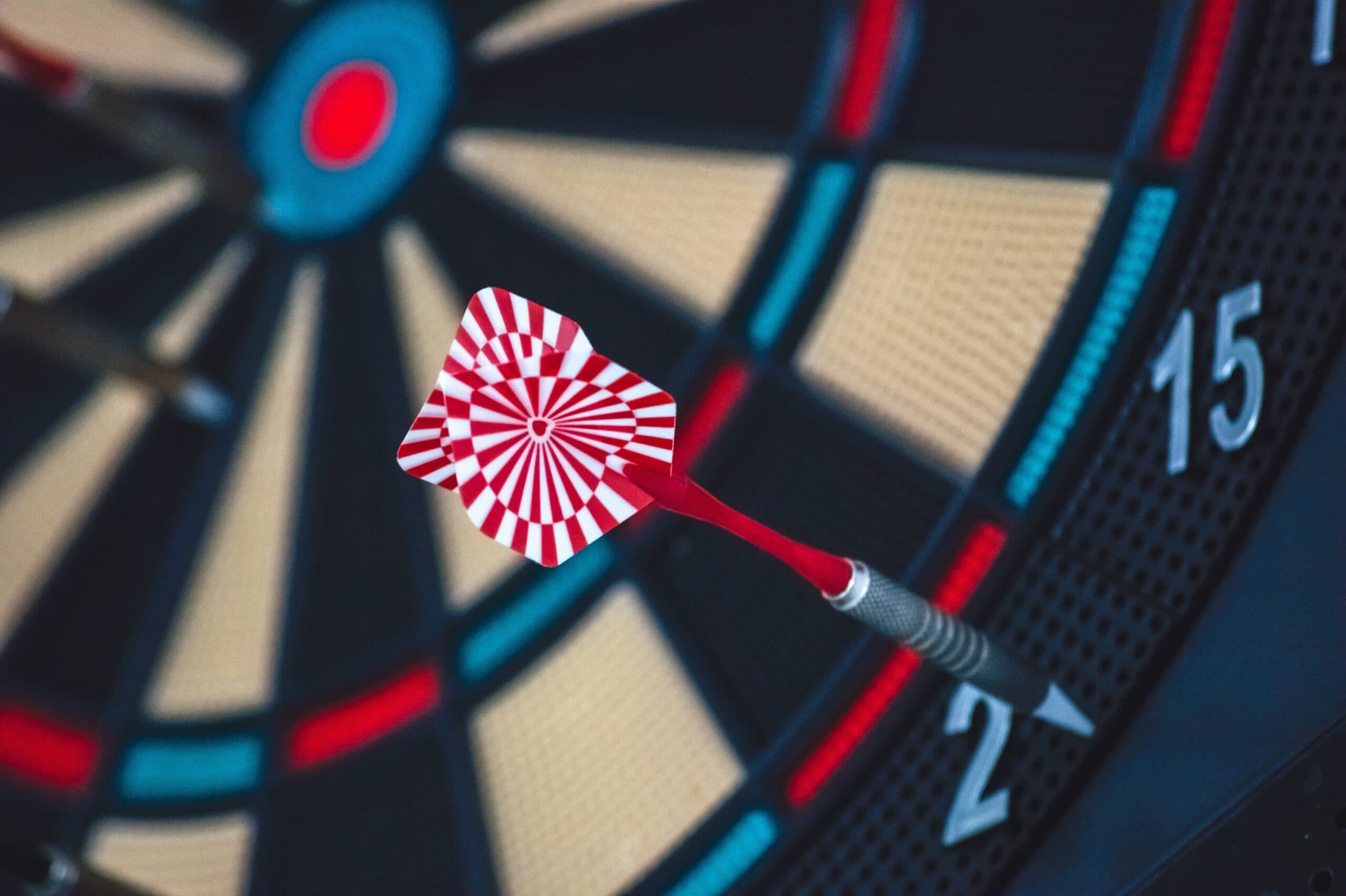 Closeup of a dartboard with one arrow stuck in the board.