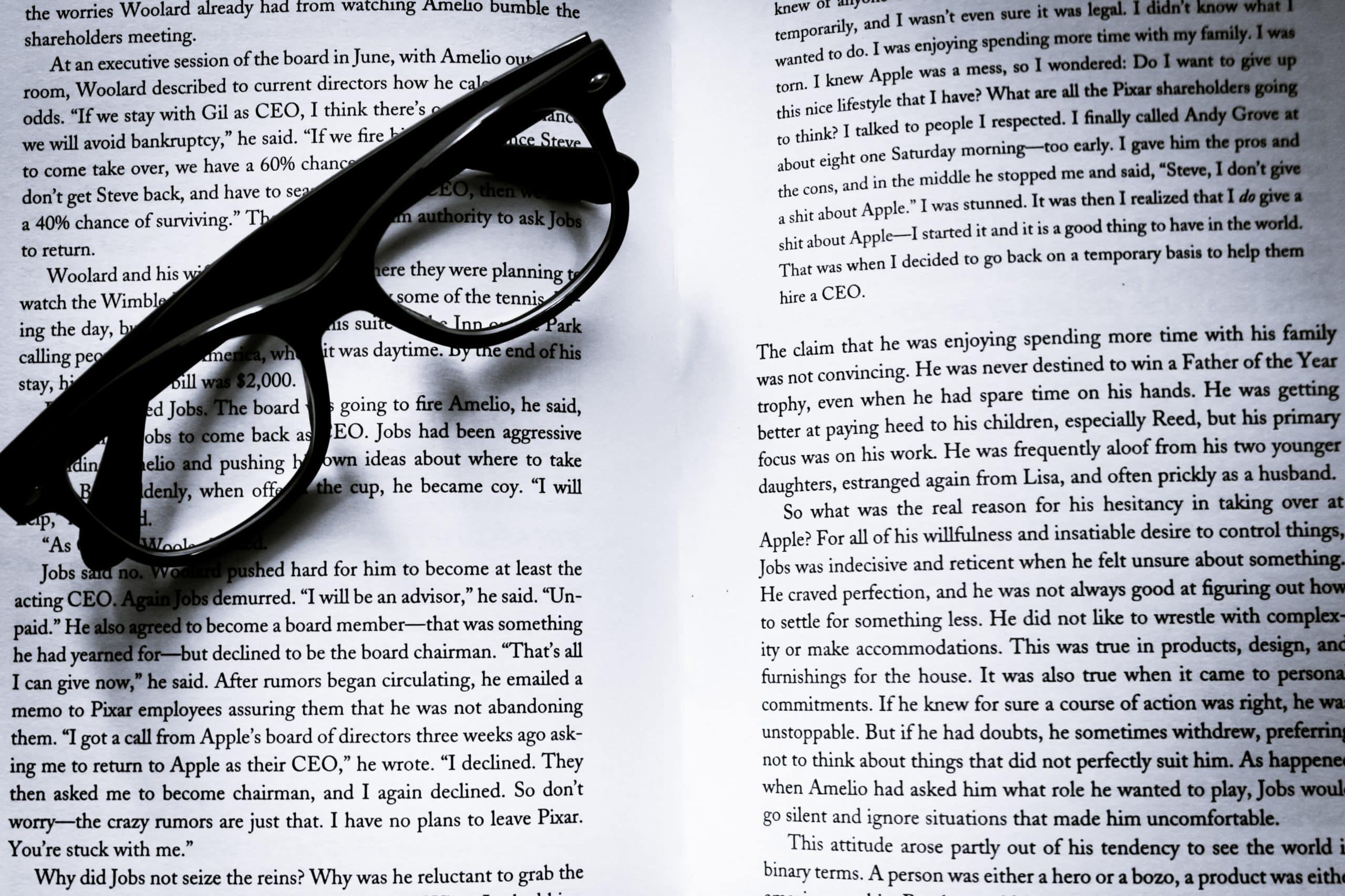 Text in an open book, with glasses on top